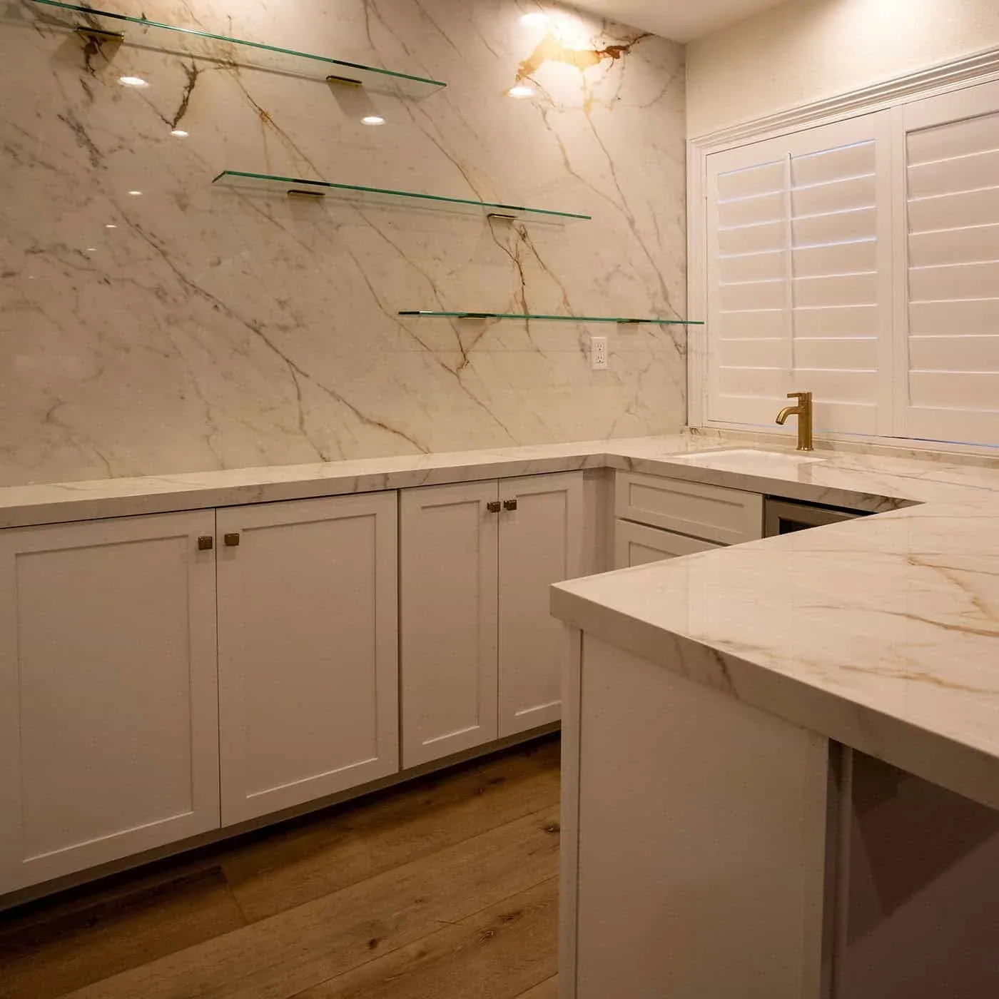 Bar run with glass shelving, marble counter and a beverage cooler