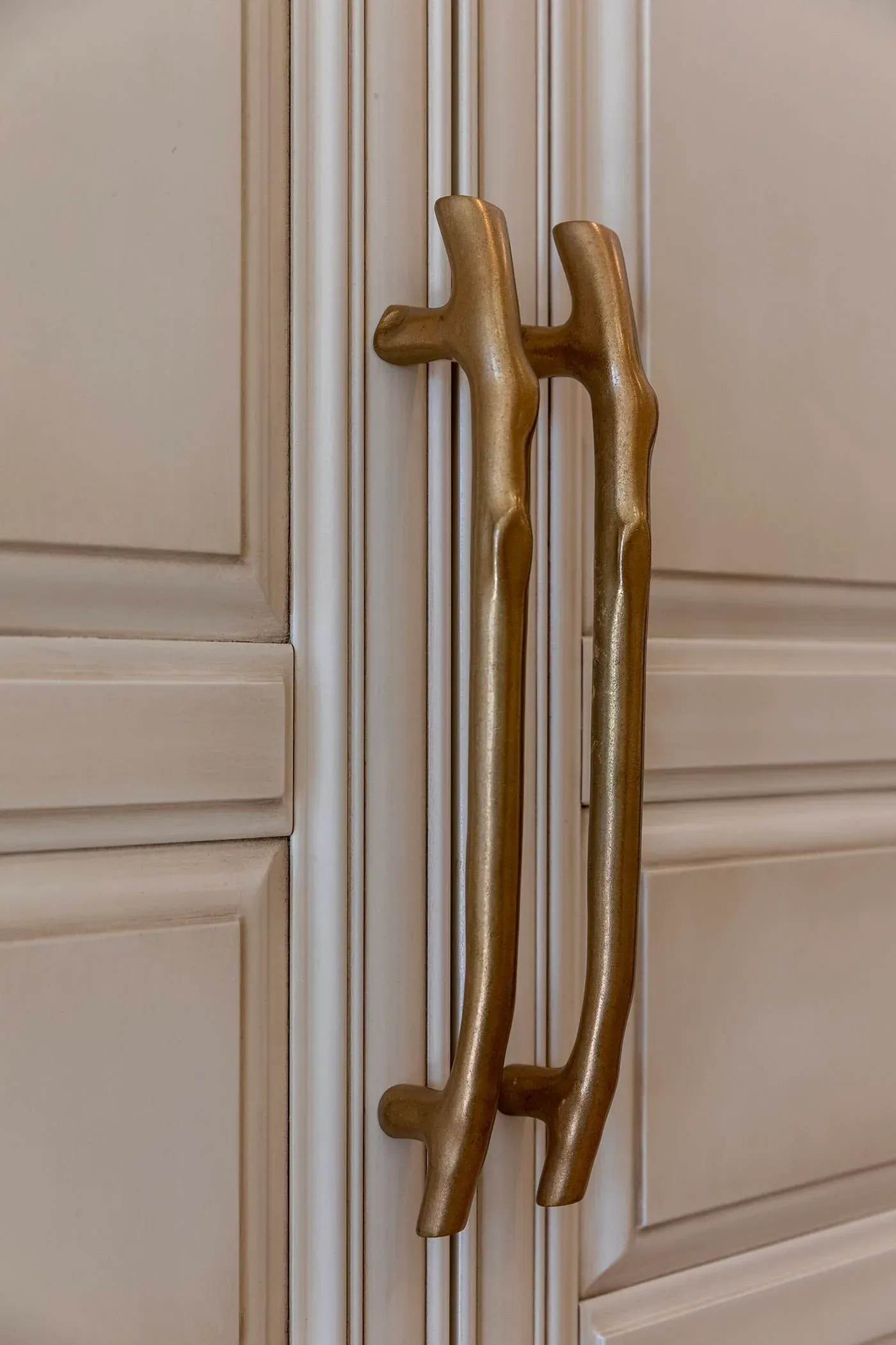 Brass appliance handles on a panelled cabinet front
