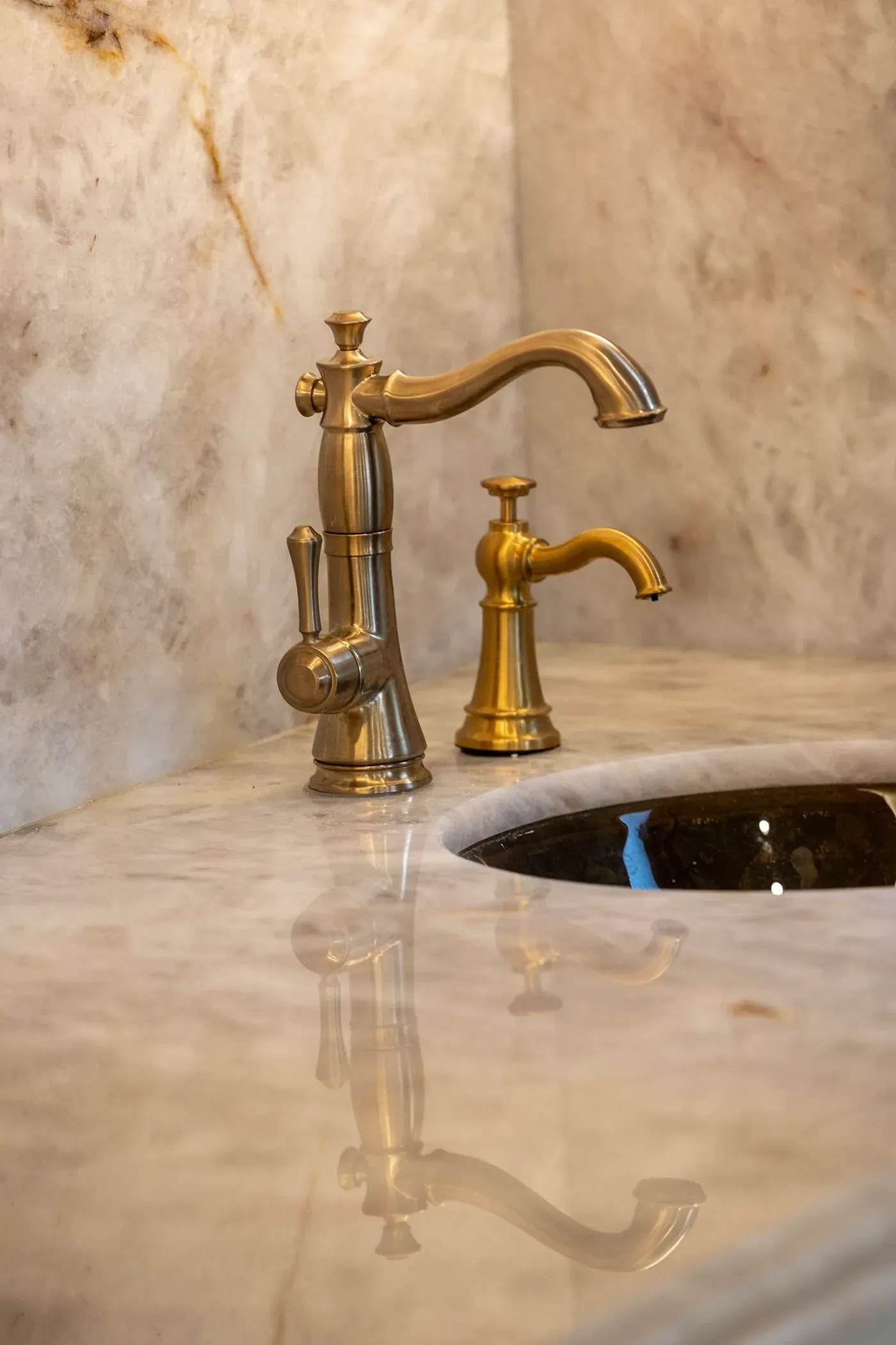 Brass bridge tap over an undermount sink in an onyx counter