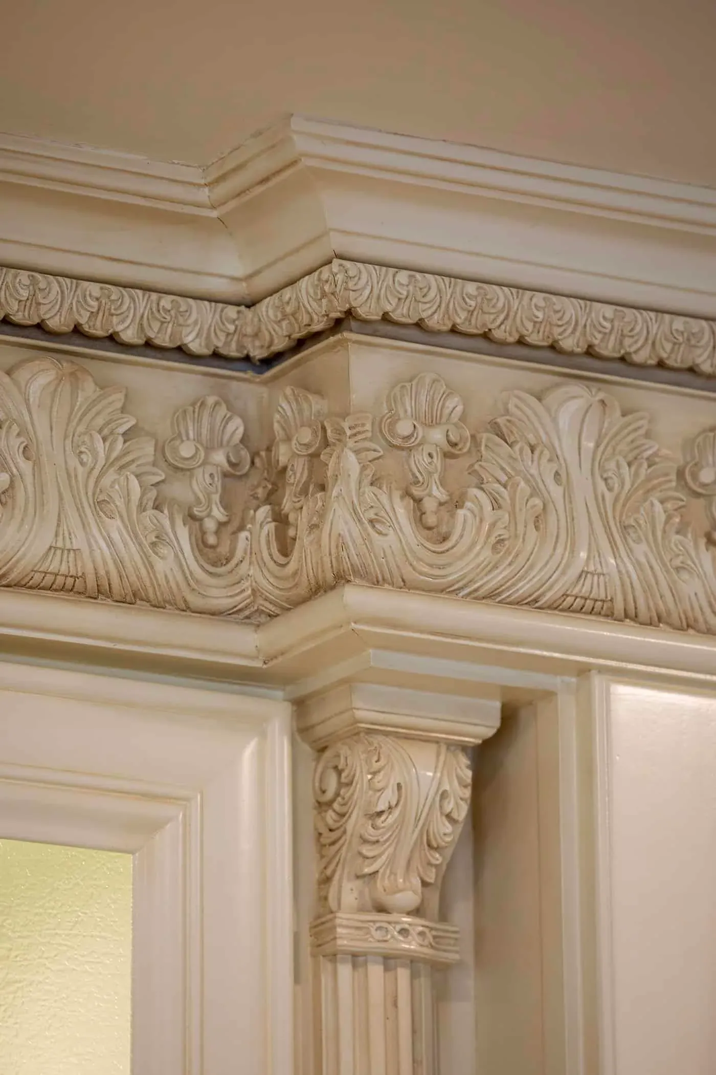 Carved acanthus frieze running above cream cabinetry