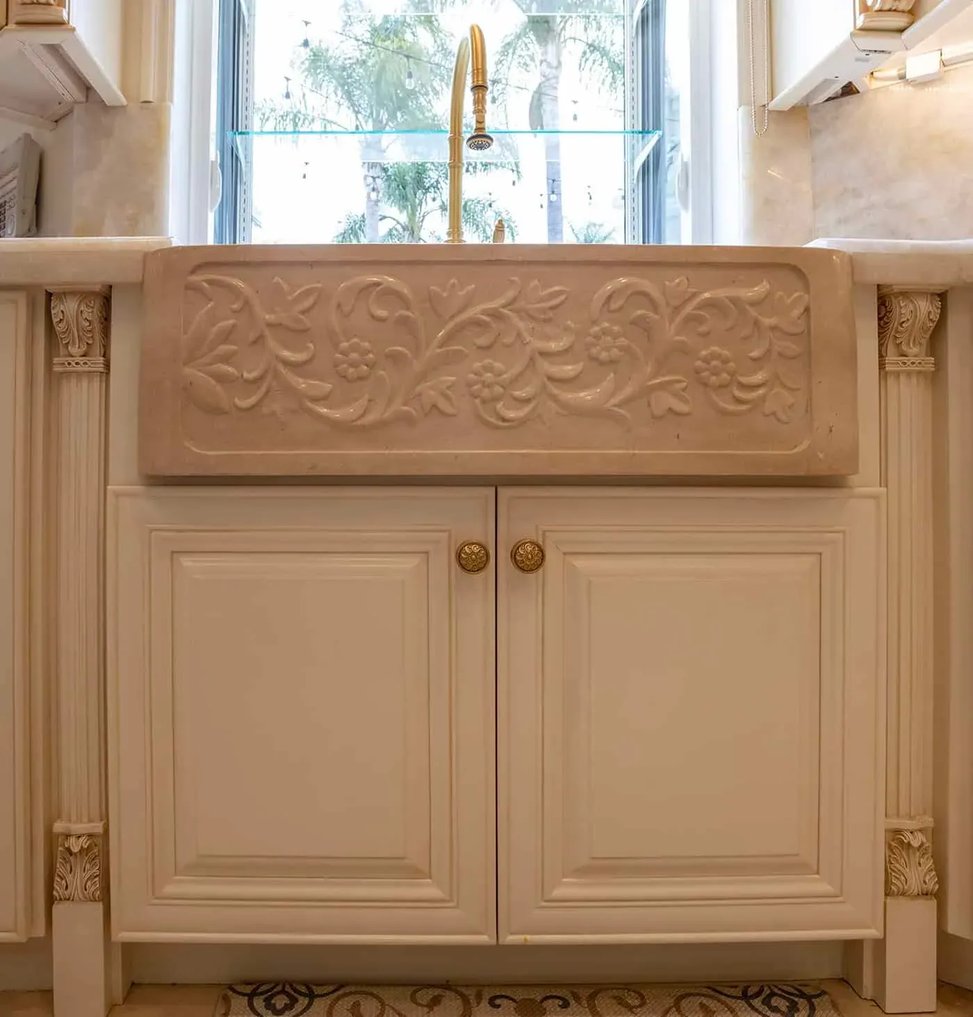 Carved cabinet panel with a floral relief above cream doors