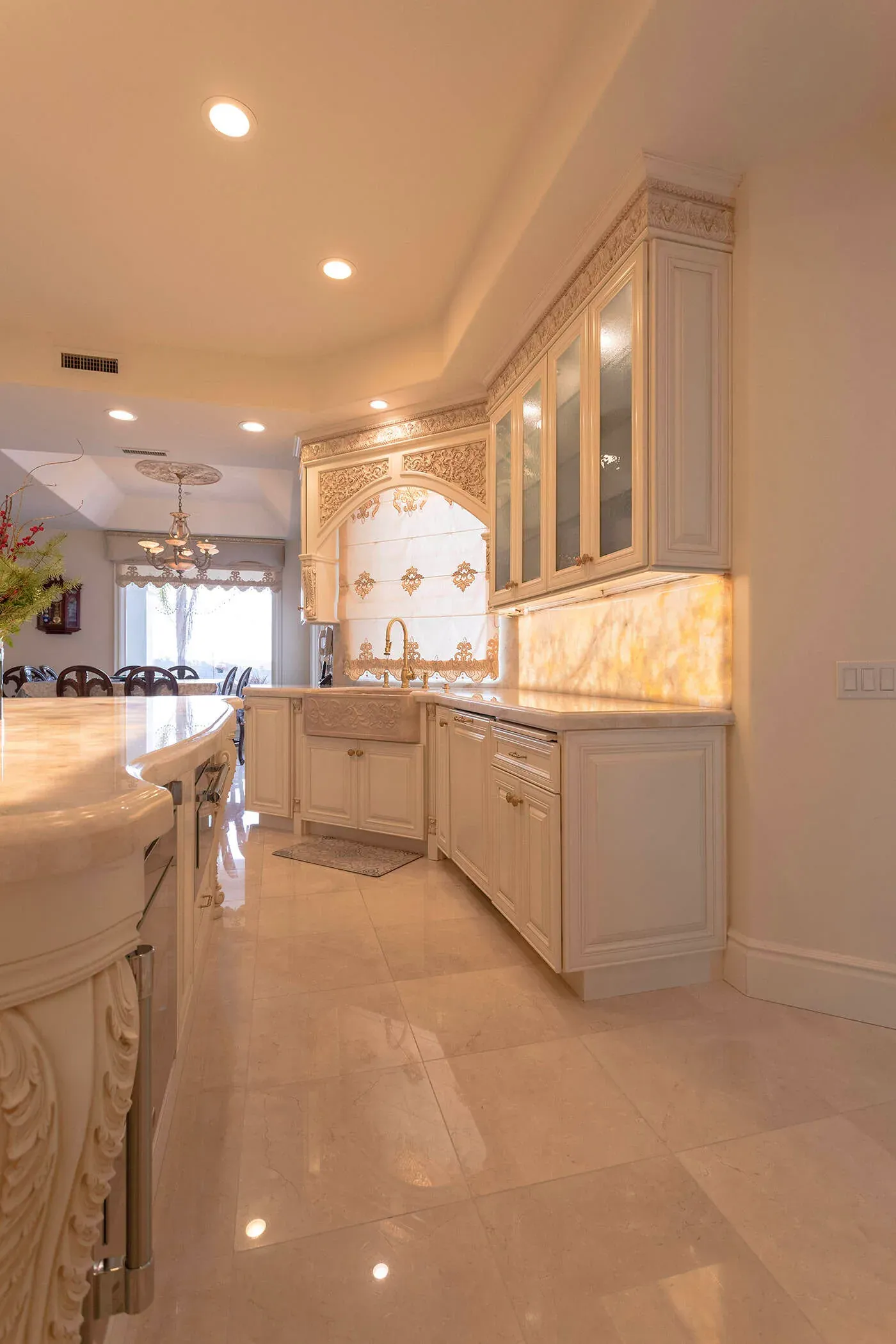Carved cabinetry with a backlit onyx panel and an arched valance