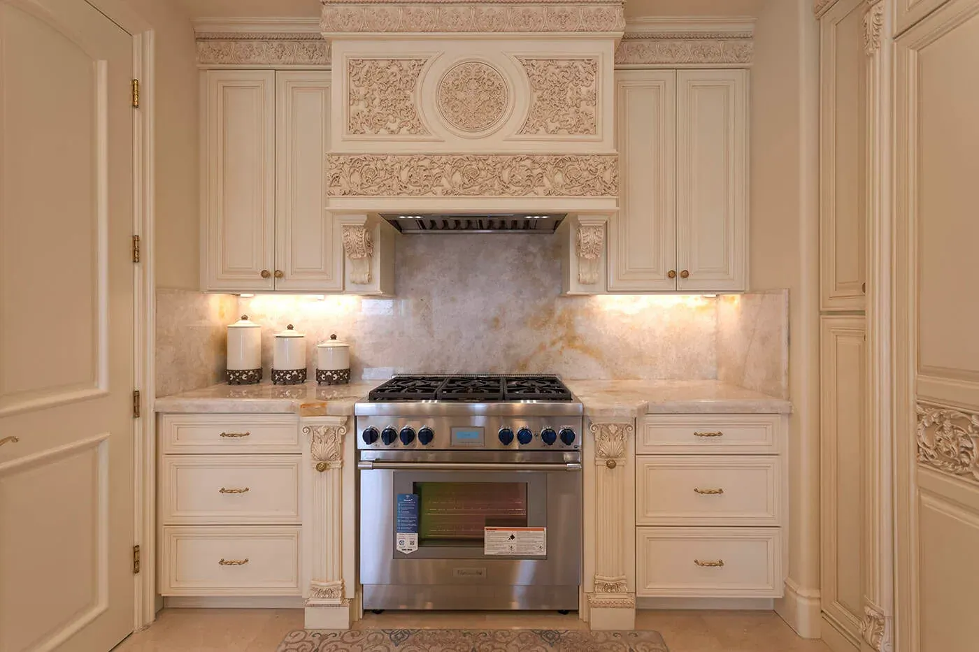 Carved hood surround with a medallion above a stainless range