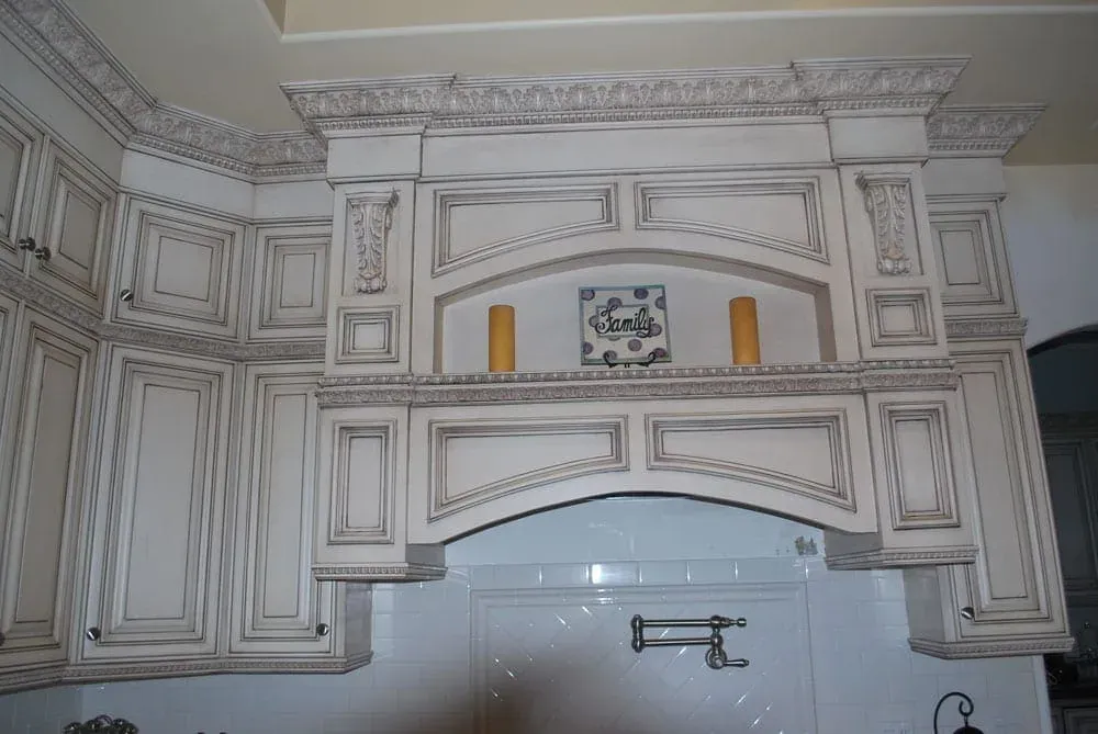 Carved hood surround with a tiled niche over a range