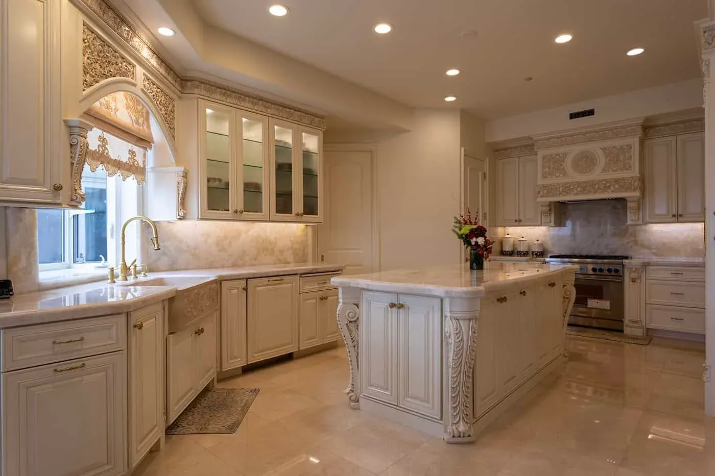 Carved island with a marble top and a professional range beyond
