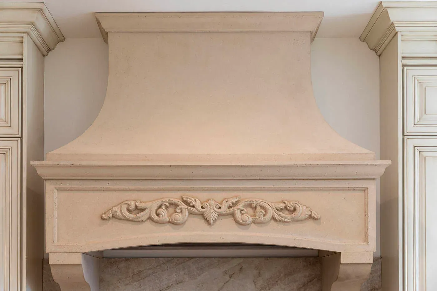 Carved plaster hood surround with a scrolled centre motif