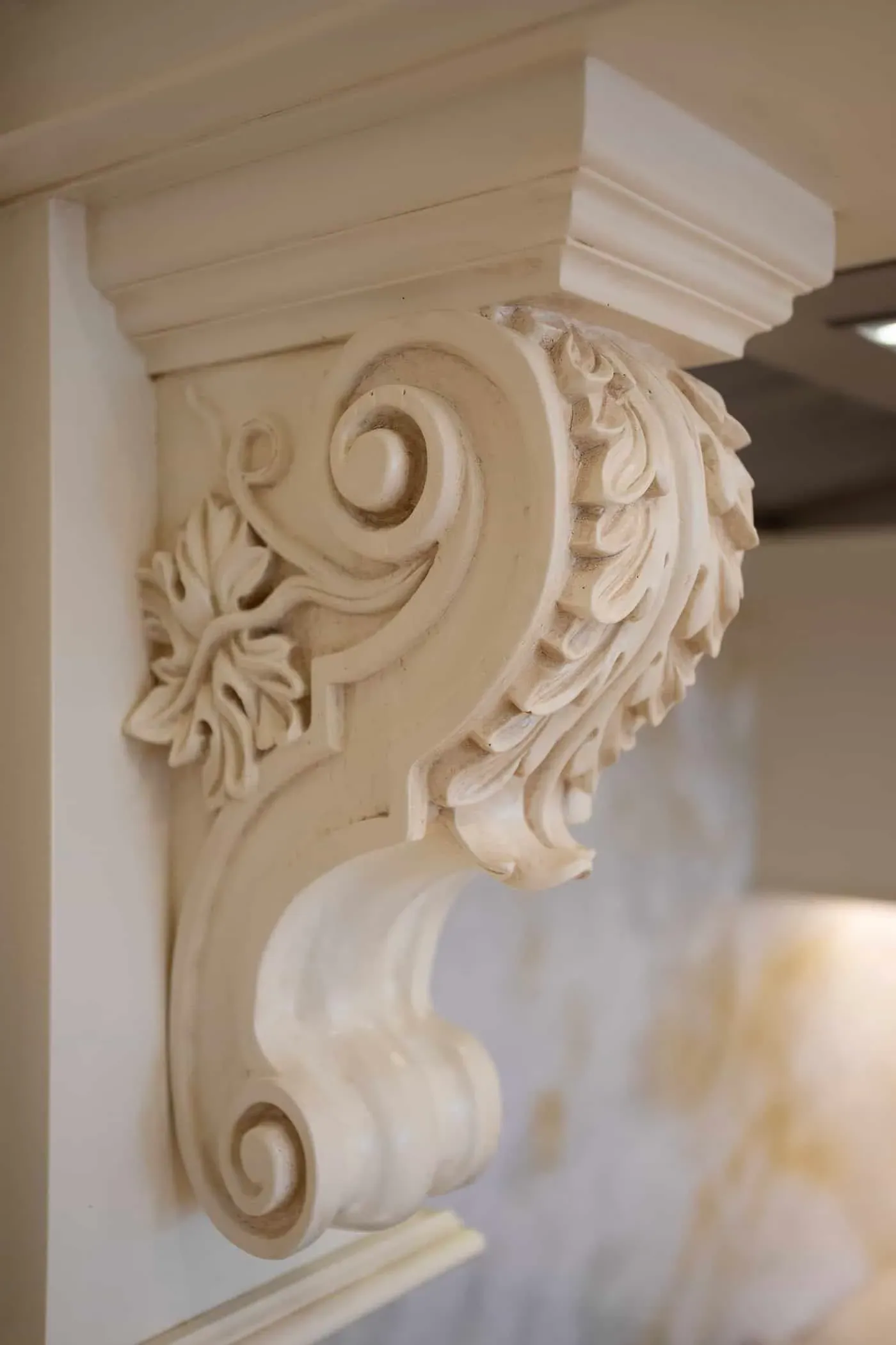 Carved scrolled corbel set against a white wall