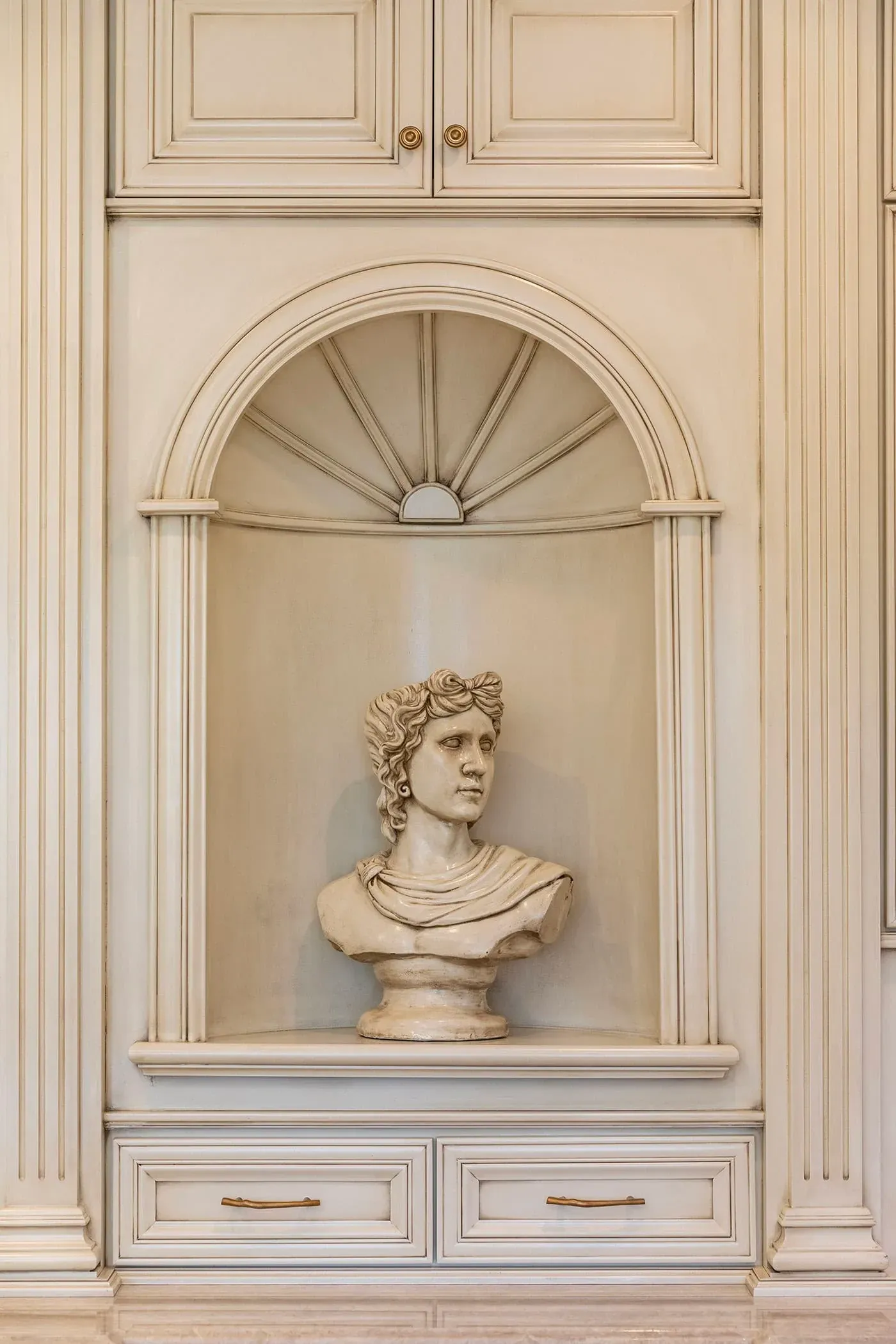 Classical bust displayed in an arched plaster niche