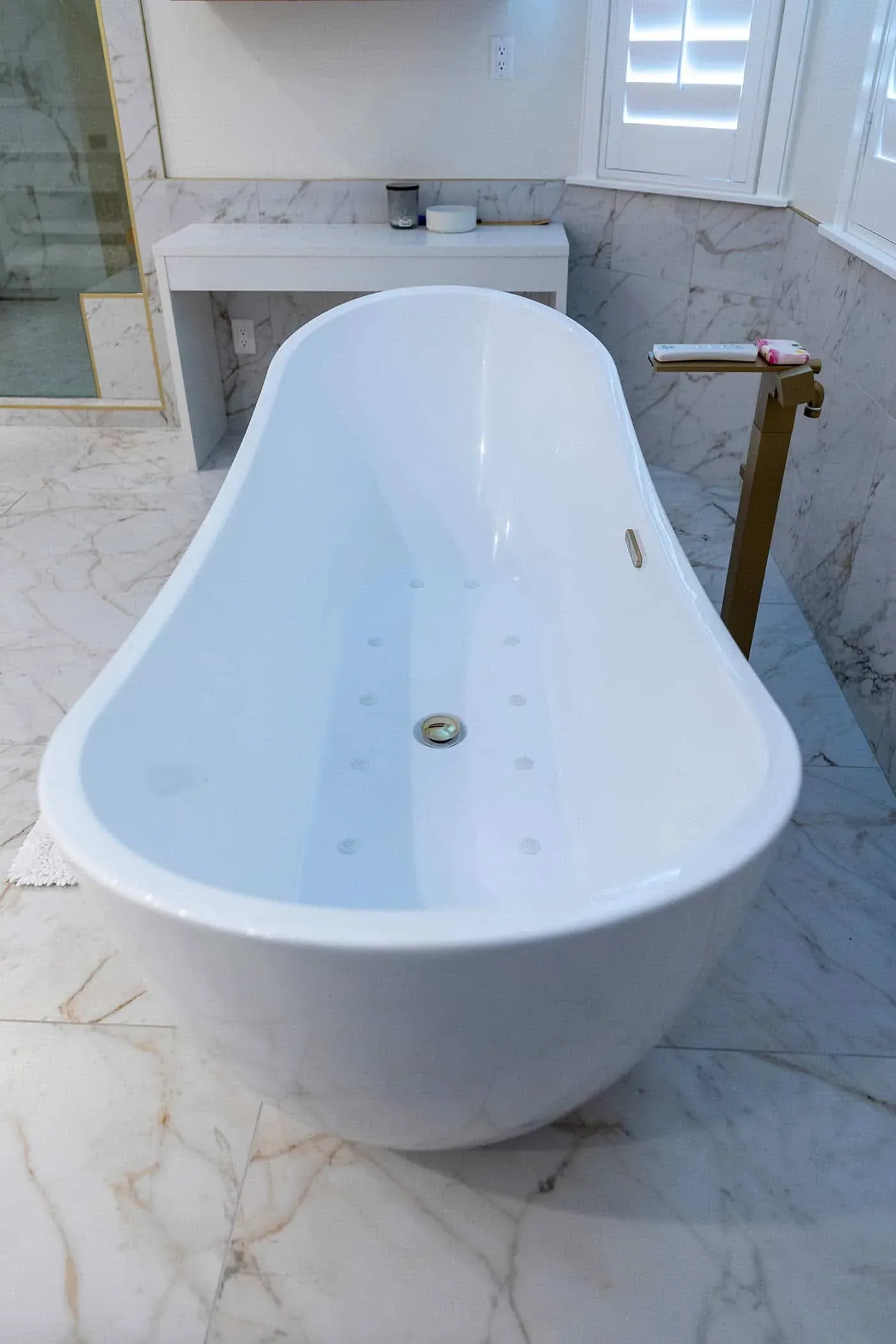 Close view of a freestanding tub with a brass floor-mounted filler