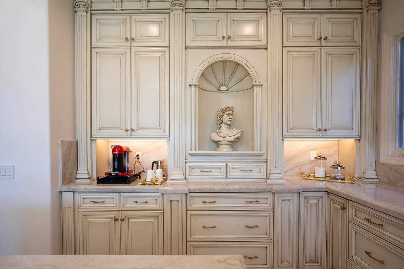 Cream cabinetry with an arched display niche holding a bust sculpture