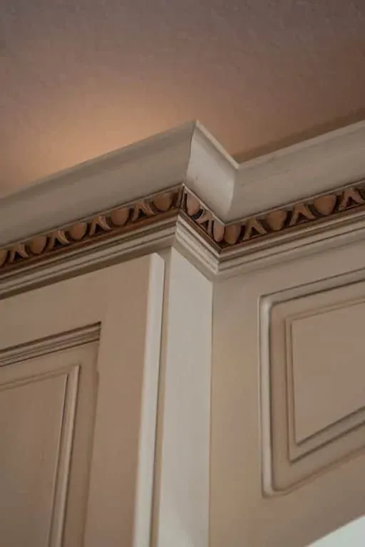 Cream cabinetry with a decorative painted crown moulding