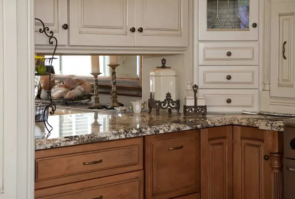 Cream cabinetry with granite counters and a window over the sink