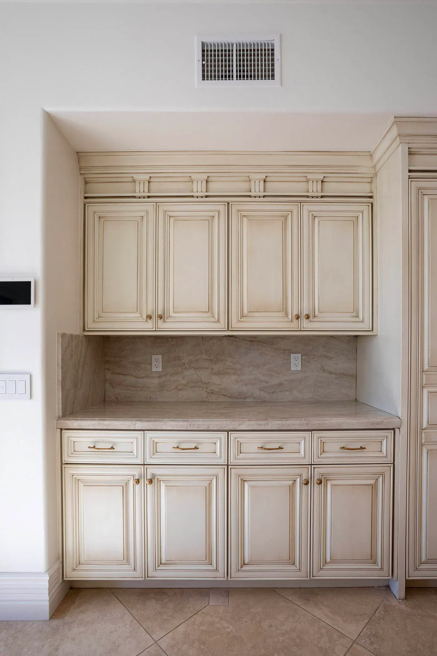 Cream cabinetry with a stone counter and an appliance garage