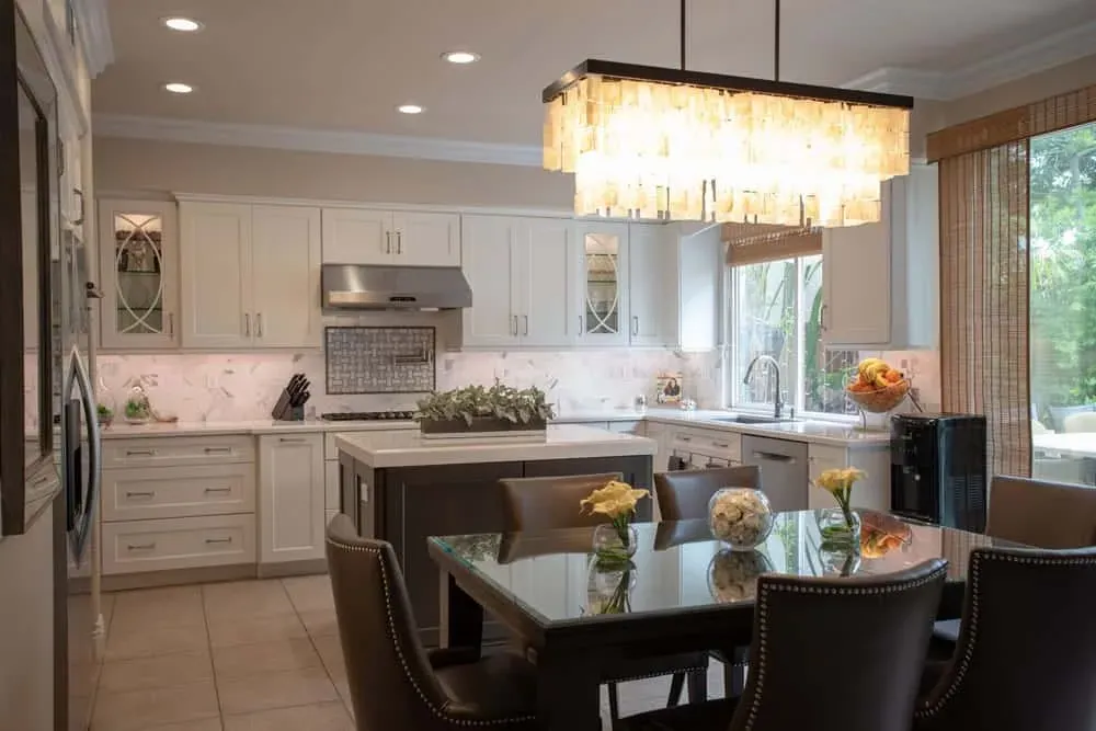 Cream kitchen and dining area with a crystal pendant and island