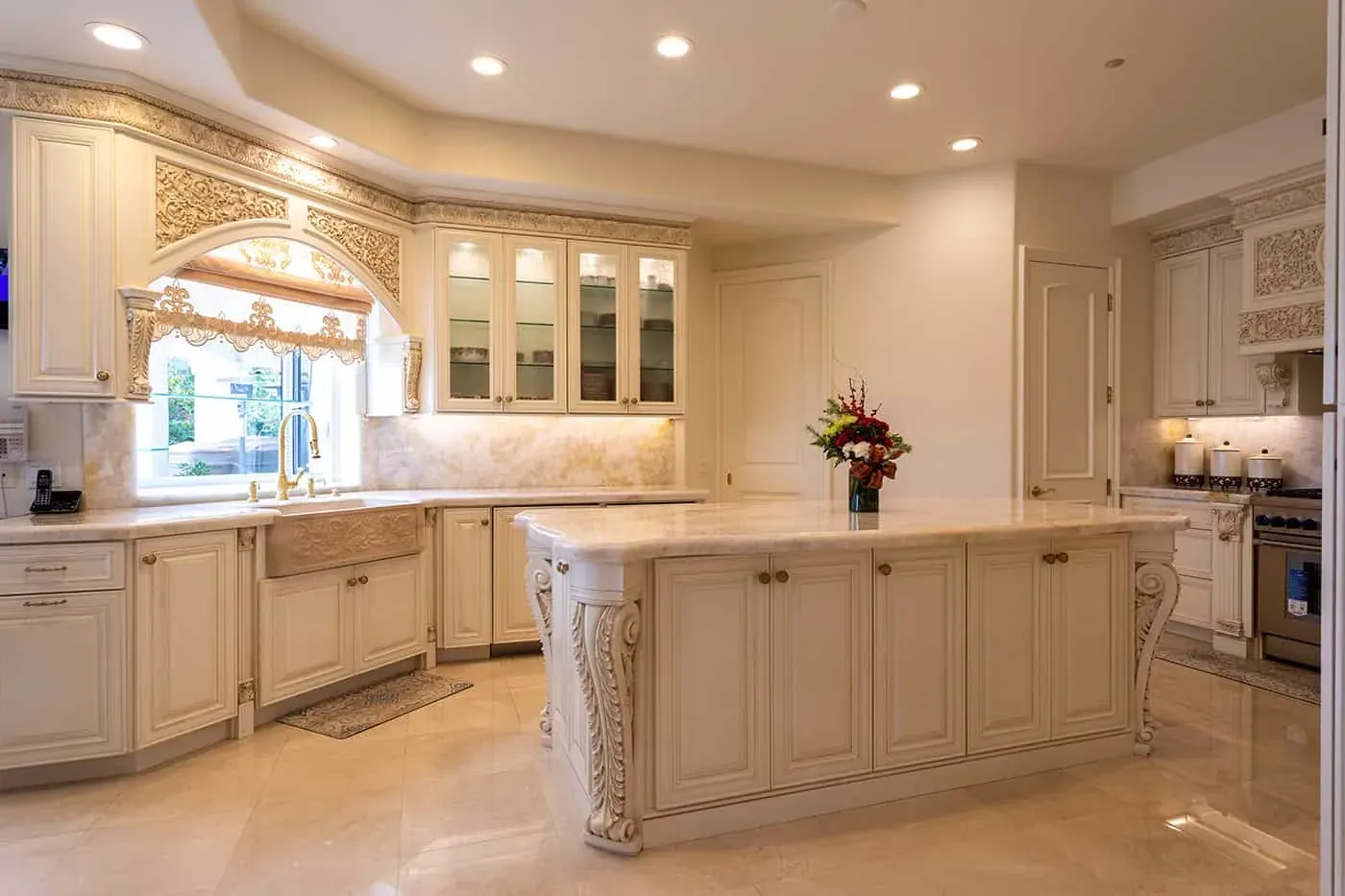 Cream kitchen with a farmhouse sink, carved island and window