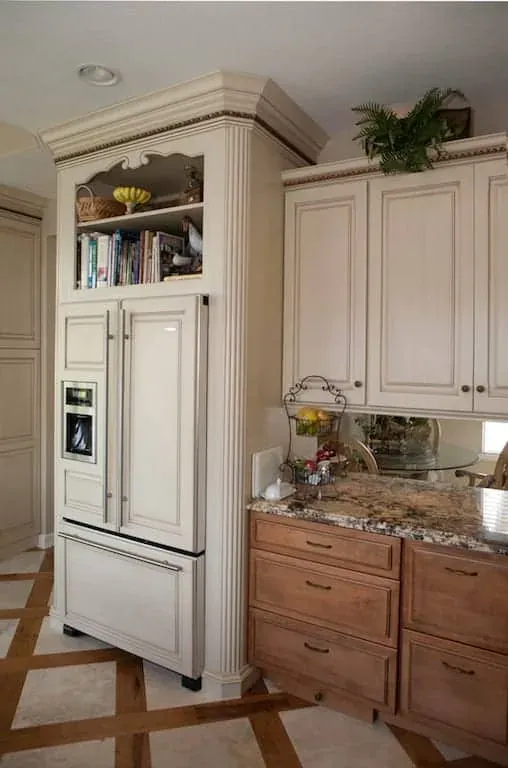 Cream kitchen with a panelled refrigerator and granite counters