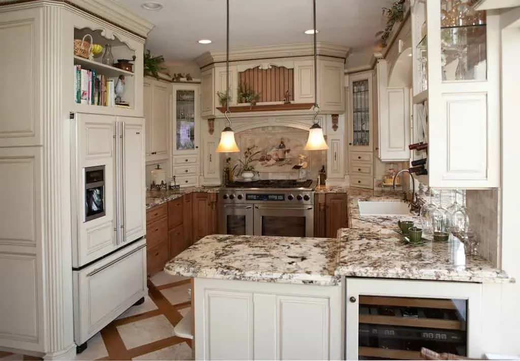 Cream kitchen with a stainless range, granite counters and glass cabinets