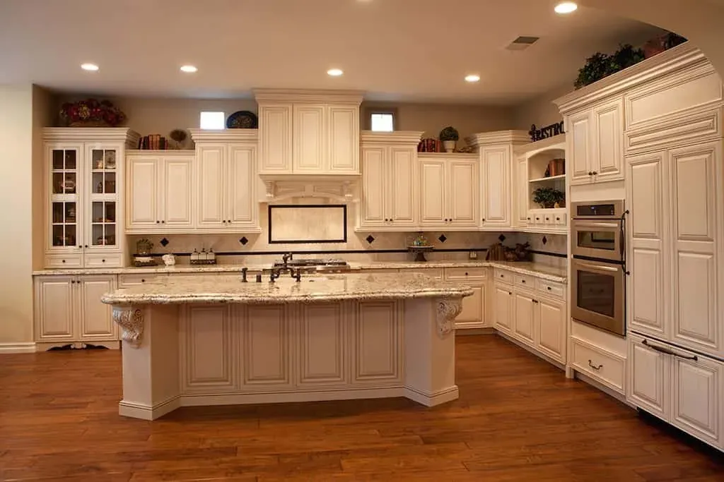 Cream traditional kitchen with a carved hood and granite island