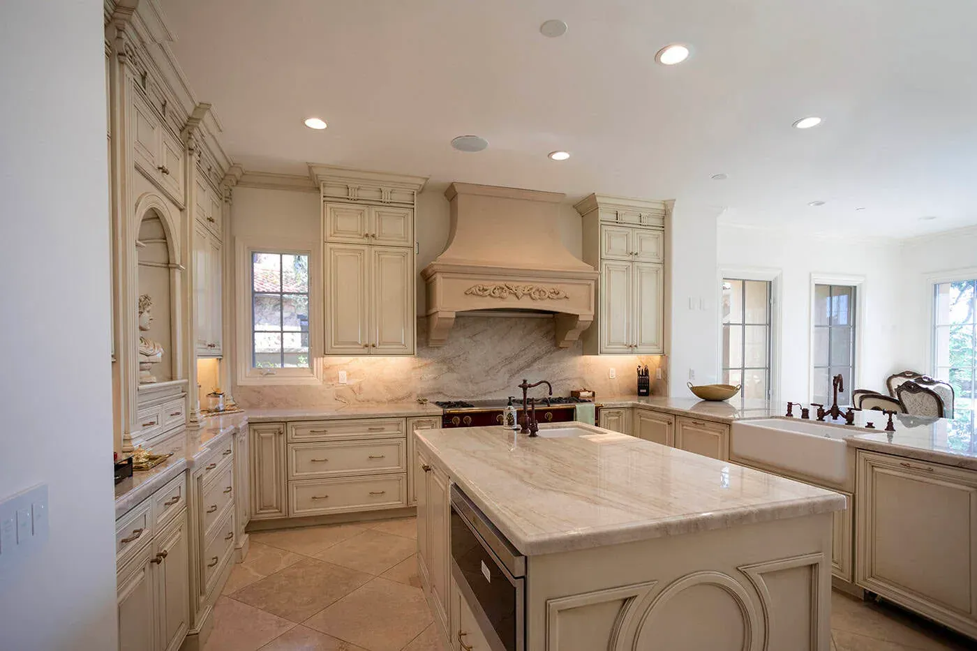 Cream traditional kitchen with a carved hood and a large stone island