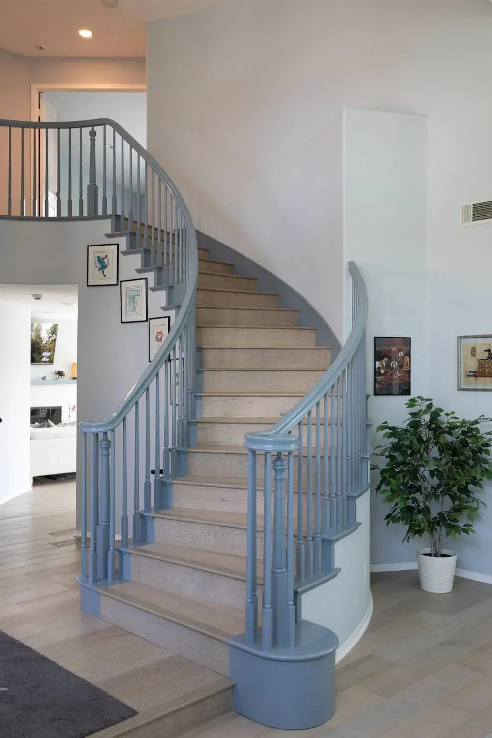 Curved staircase with a painted balustrade and wood treads
