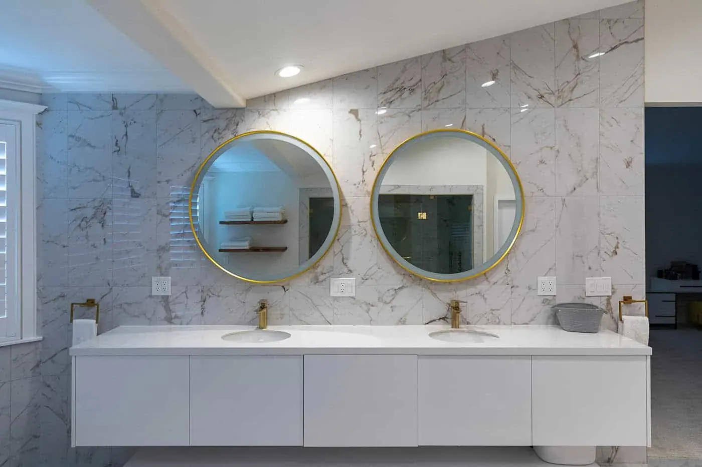 Double floating vanity with two round gold mirrors and brass taps