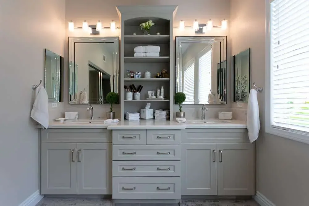 Double vanity with two mirrors, wall sconces and open shelving