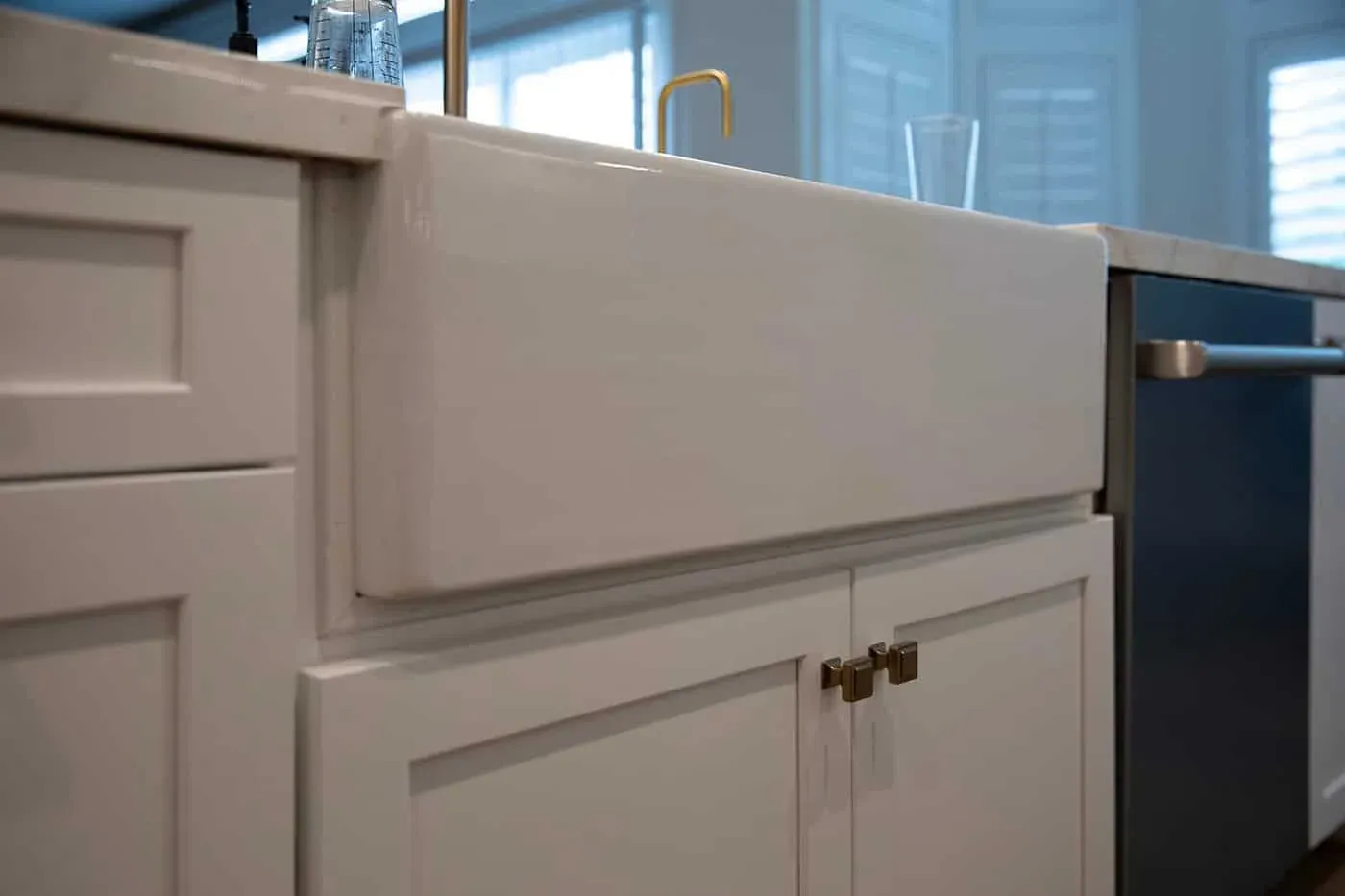 Farmhouse apron sink set into white shaker cabinetry
