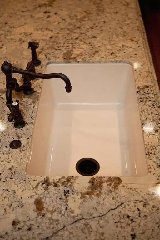 Farmhouse sink and bronze tap set into granite