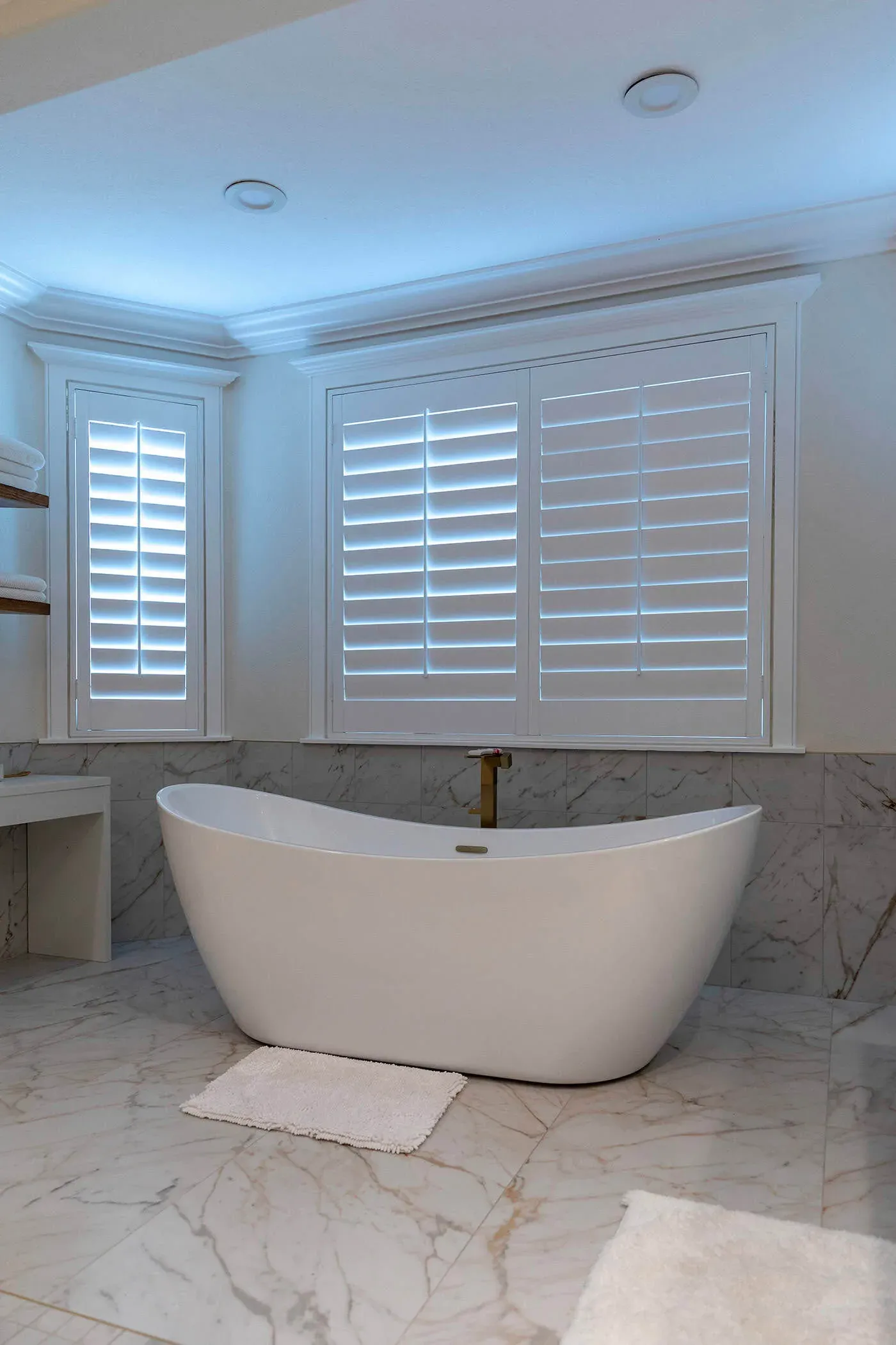 Freestanding slipper tub beneath shuttered windows