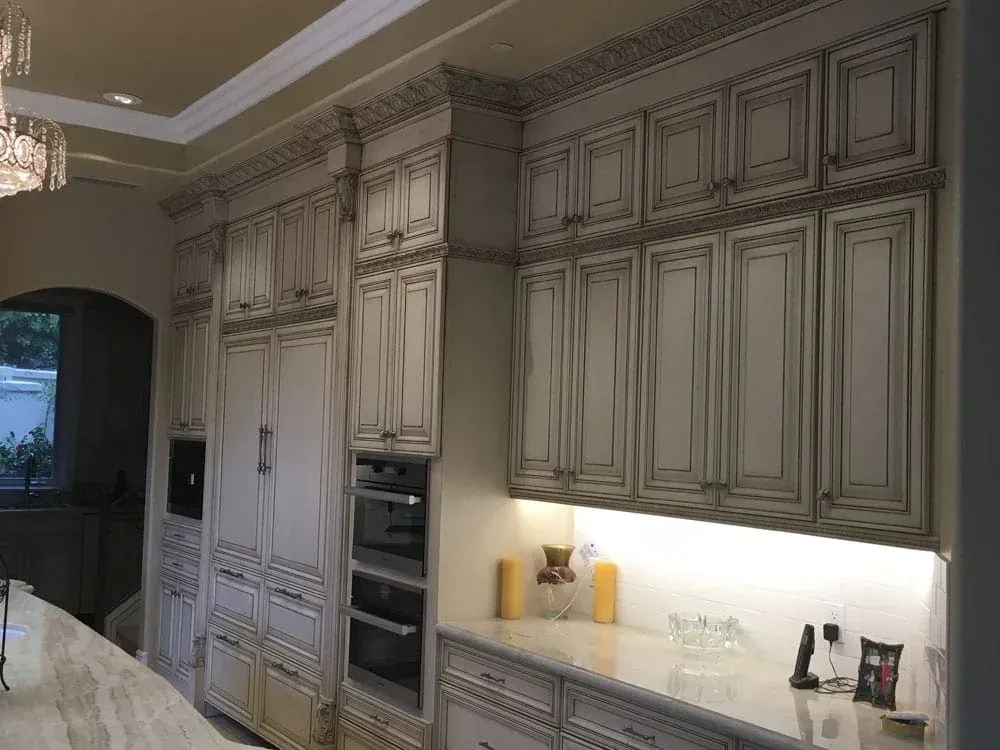 Glazed cabinetry wall with double wall ovens and under-cabinet lighting