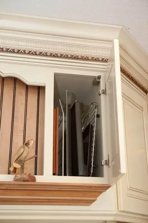 Open cabinet storing baking trays vertically