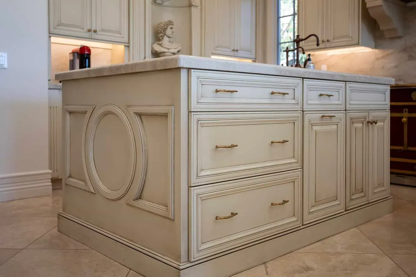 Kitchen island with oval panel detailing and bronze hardware