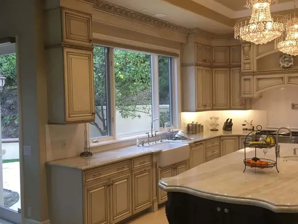 Kitchen with a window over the sink, a crystal chandelier and a large glazed island