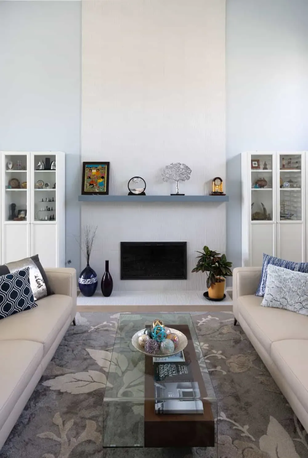 Living room with a fireplace, built-in cabinets and a floating shelf