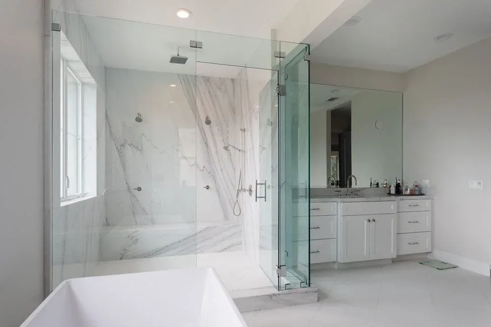 Marble bathroom with a glass shower, tub and vanity mirror
