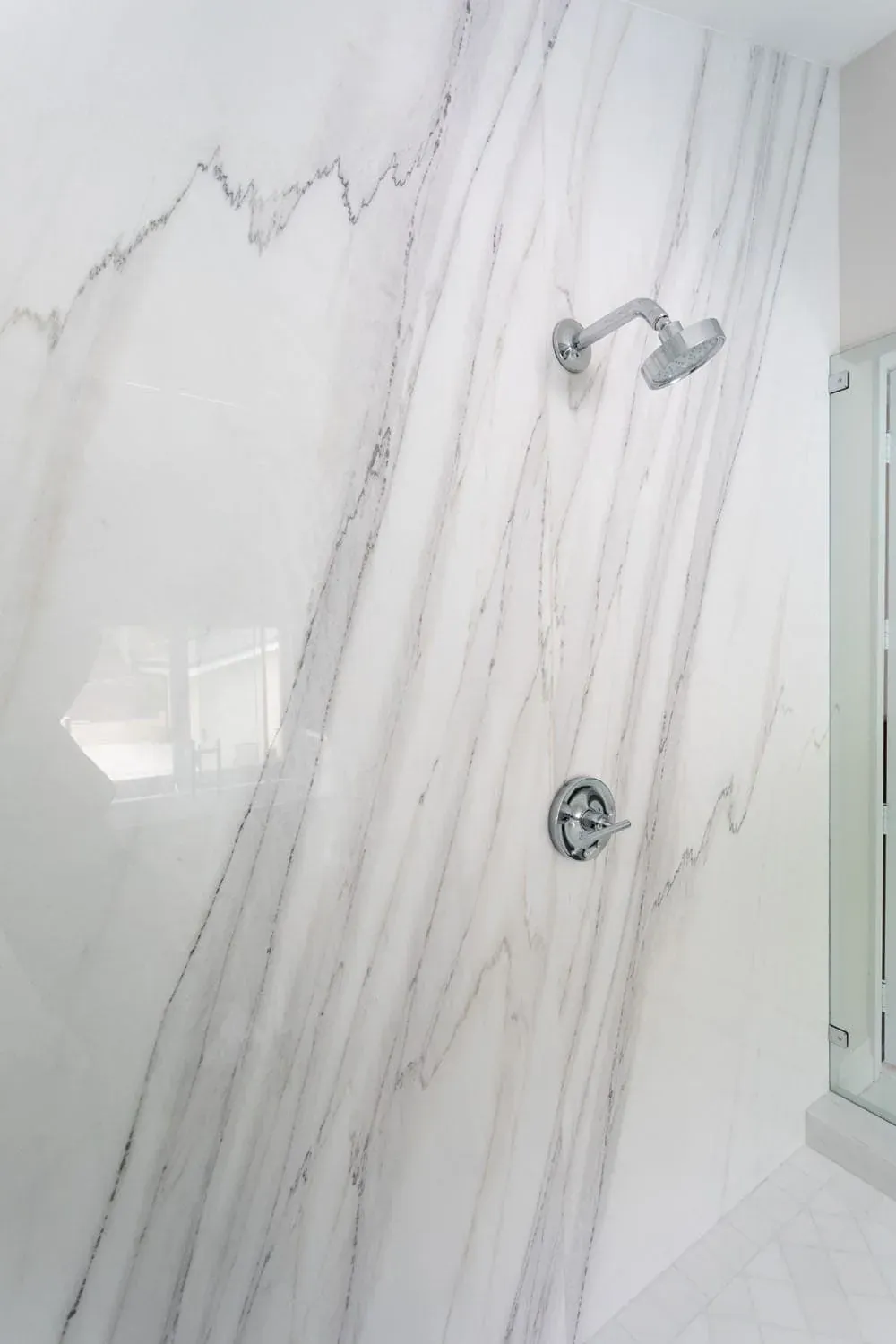 Marble slab shower wall with a chrome shower head
