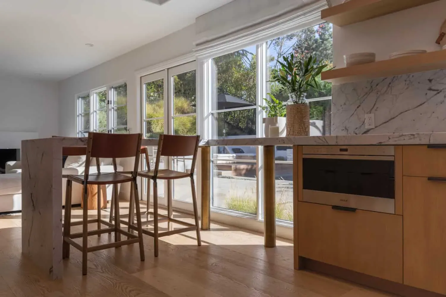 Oak kitchen with bar stools at the island and sliding doors to the garden