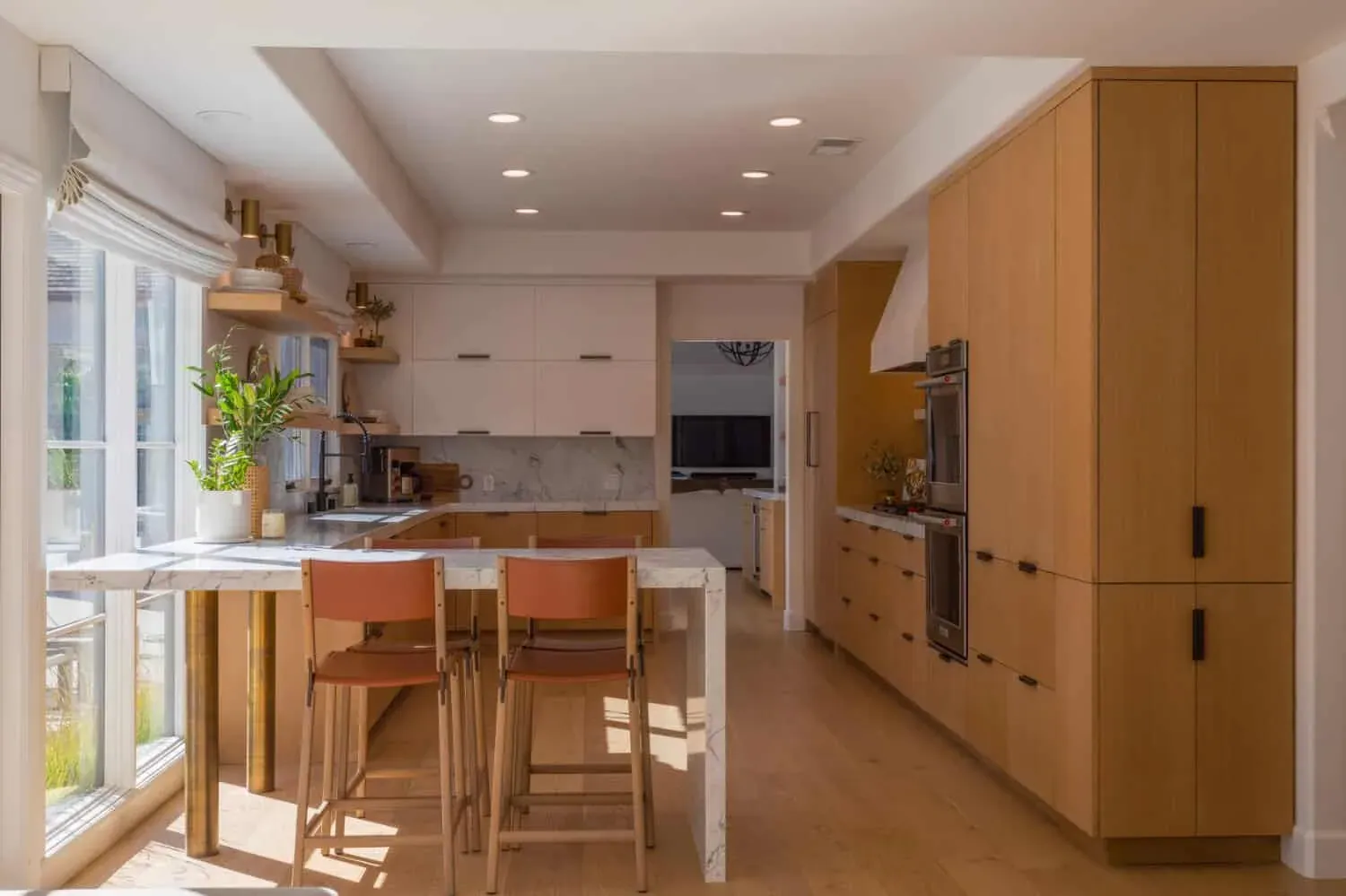 Oak kitchen with a marble island, bar stools and French doors