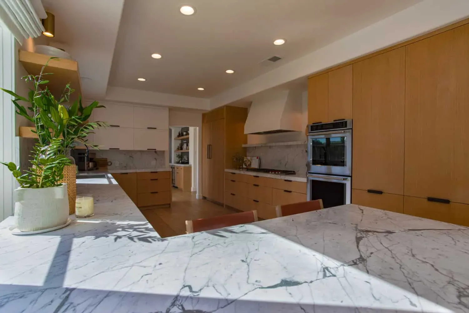 Oak kitchen with open shelving, a plaster hood and a marble island