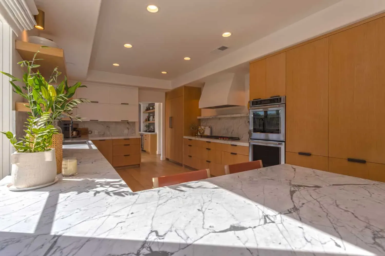 Oak kitchen with a plaster hood, marble island and open shelves
