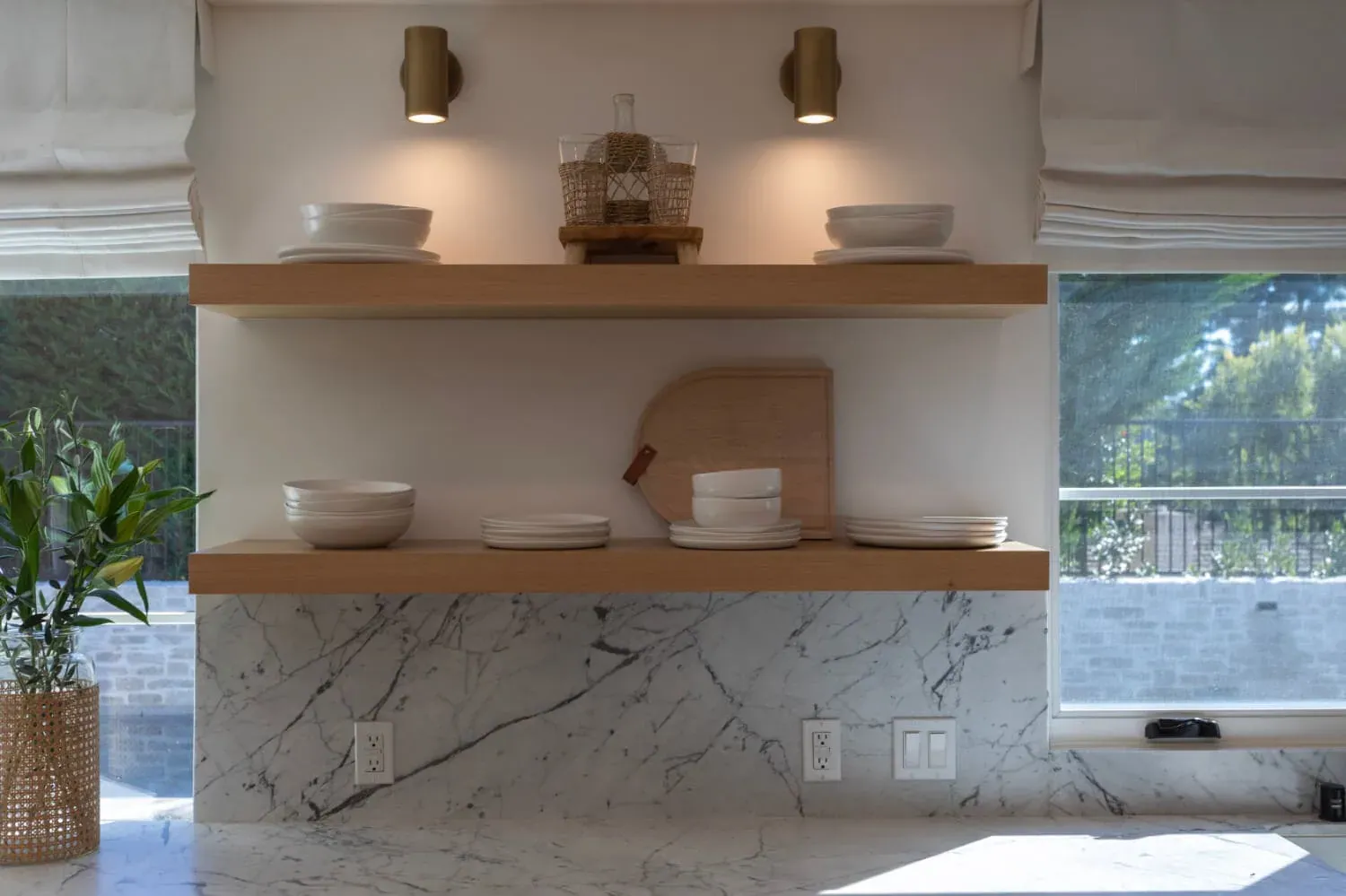 Open oak shelving against a marble slab backsplash