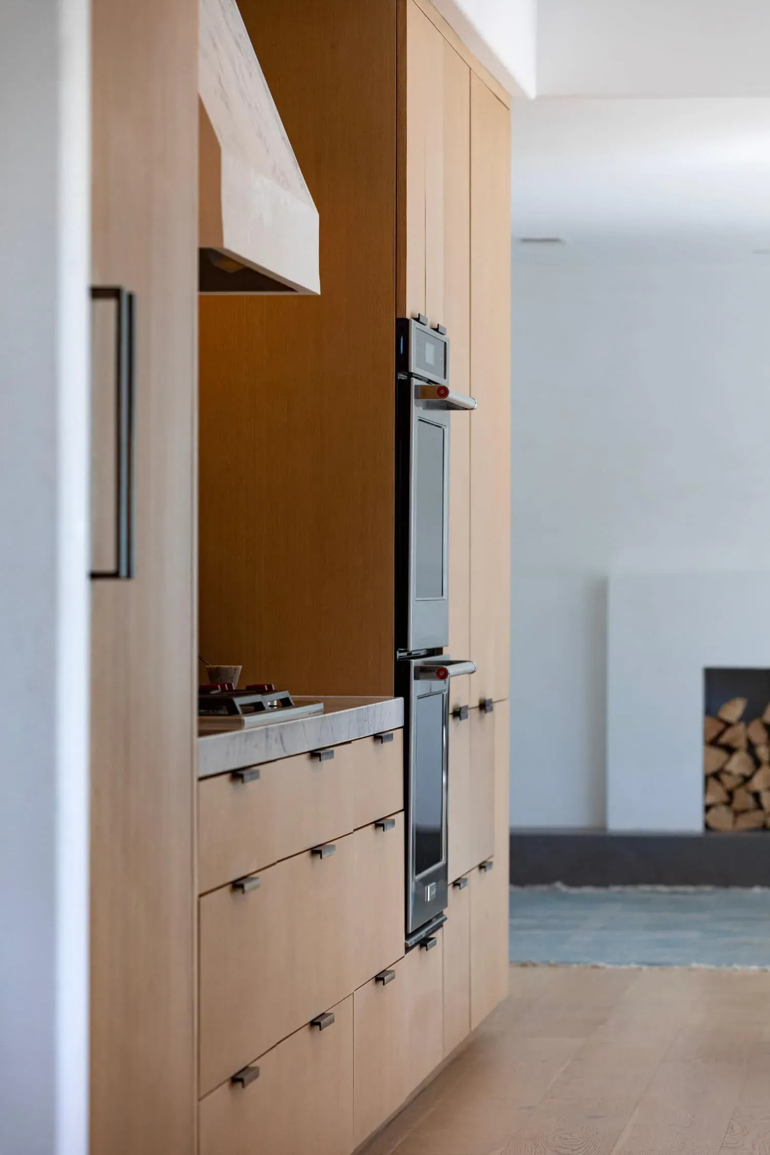 Panelled oak cabinetry beside a stainless wall oven