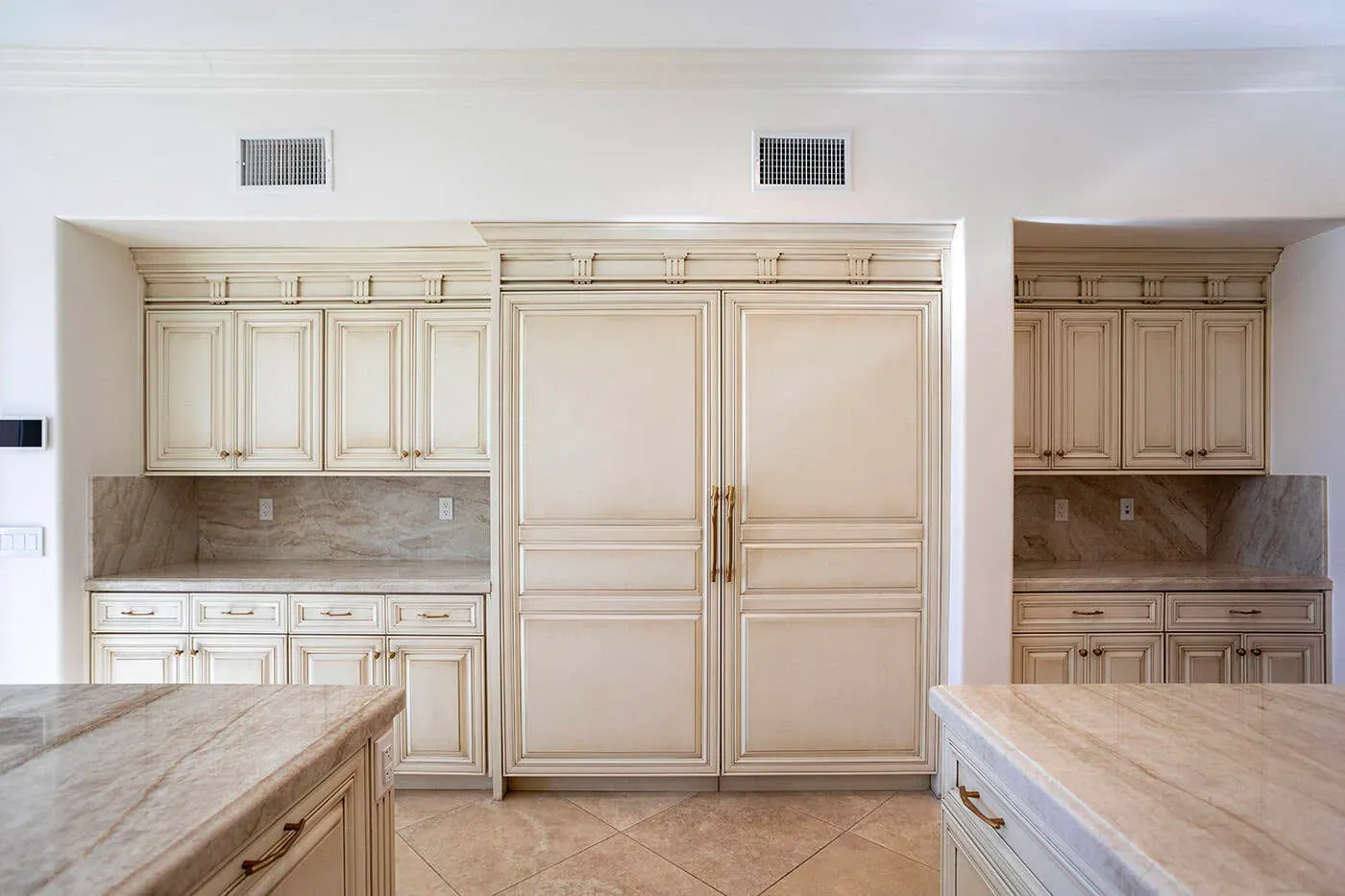 Panelled refrigerator integrated into cream traditional cabinetry