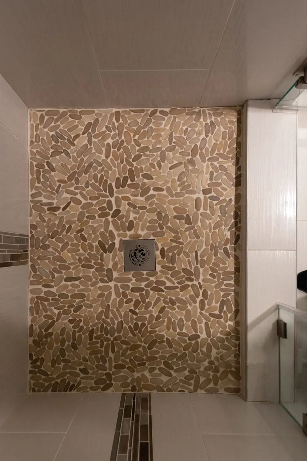 Pebble-tiled shower wall with a mosaic niche