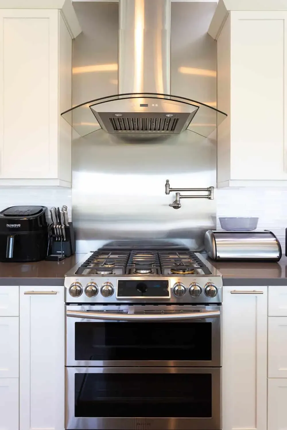 Stainless range with a pot filler and a stainless backsplash