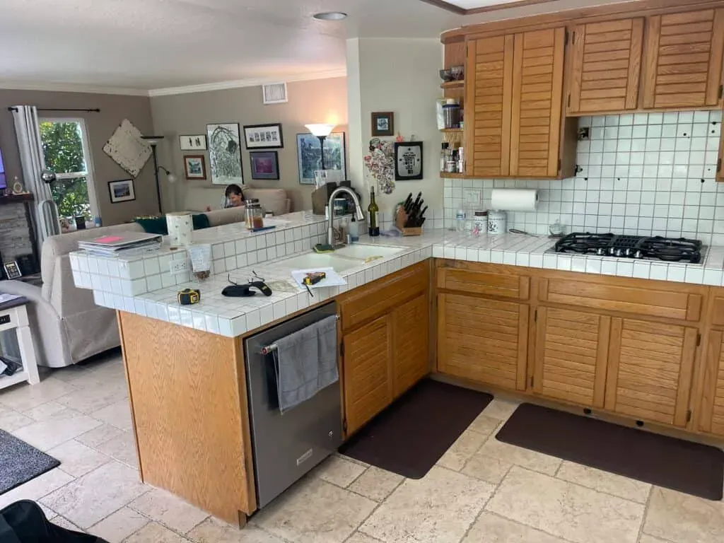 U-shaped oak kitchen with white tile countertops before remodeling