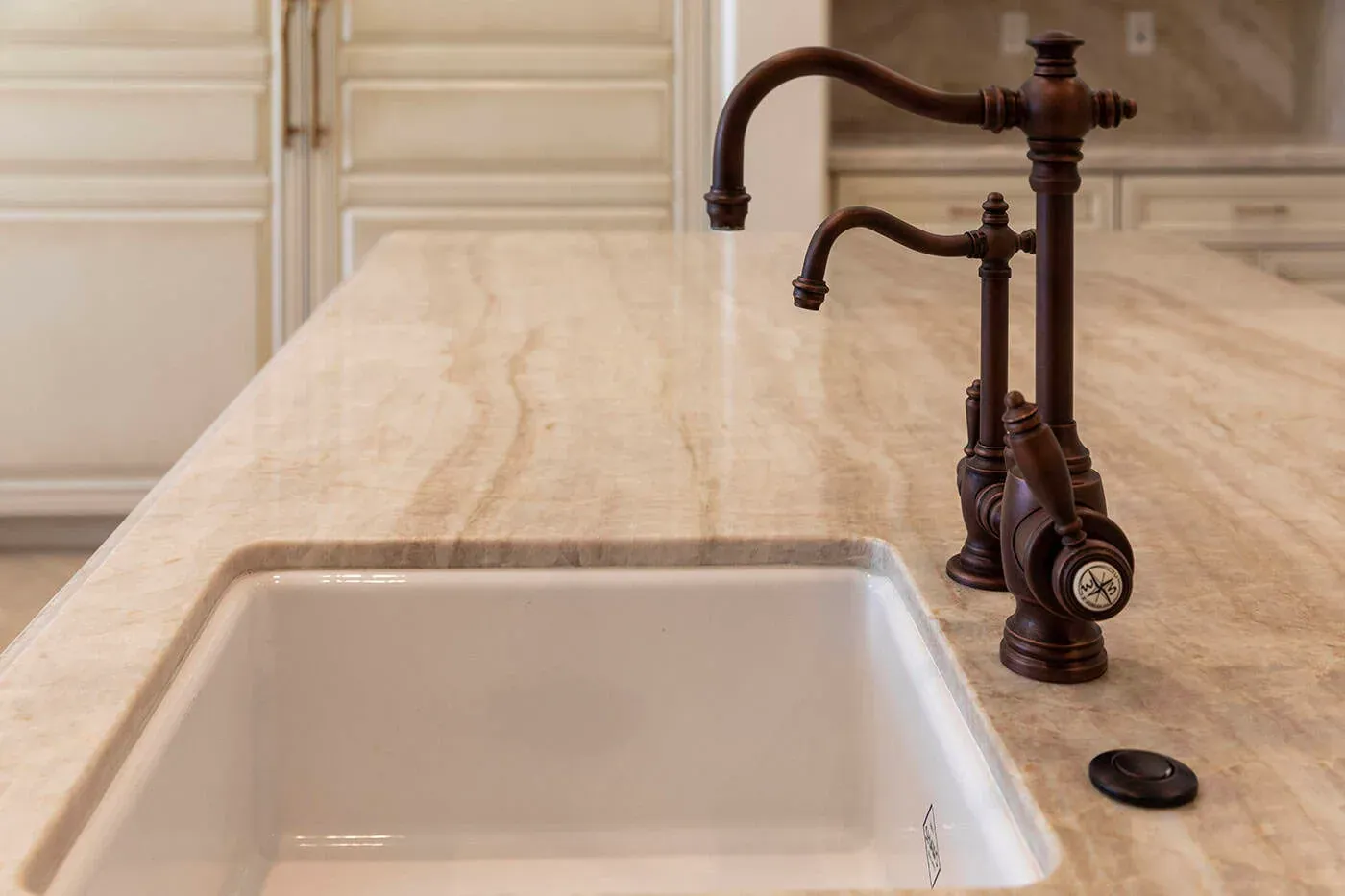 Undermount sink with a bronze articulated tap on a stone worktop