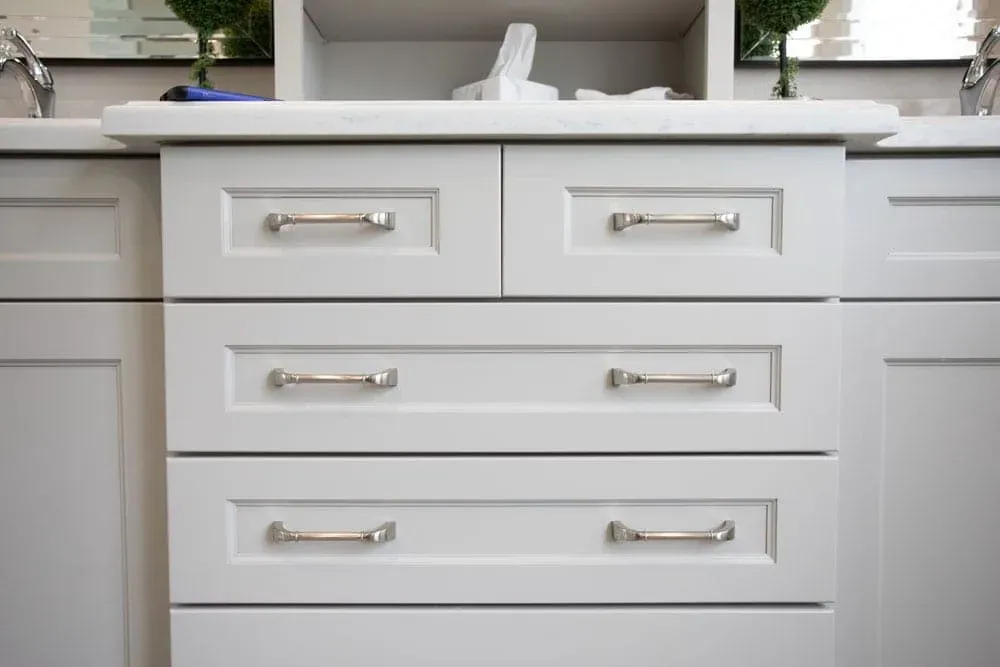 White vanity drawers with polished chrome bar pulls